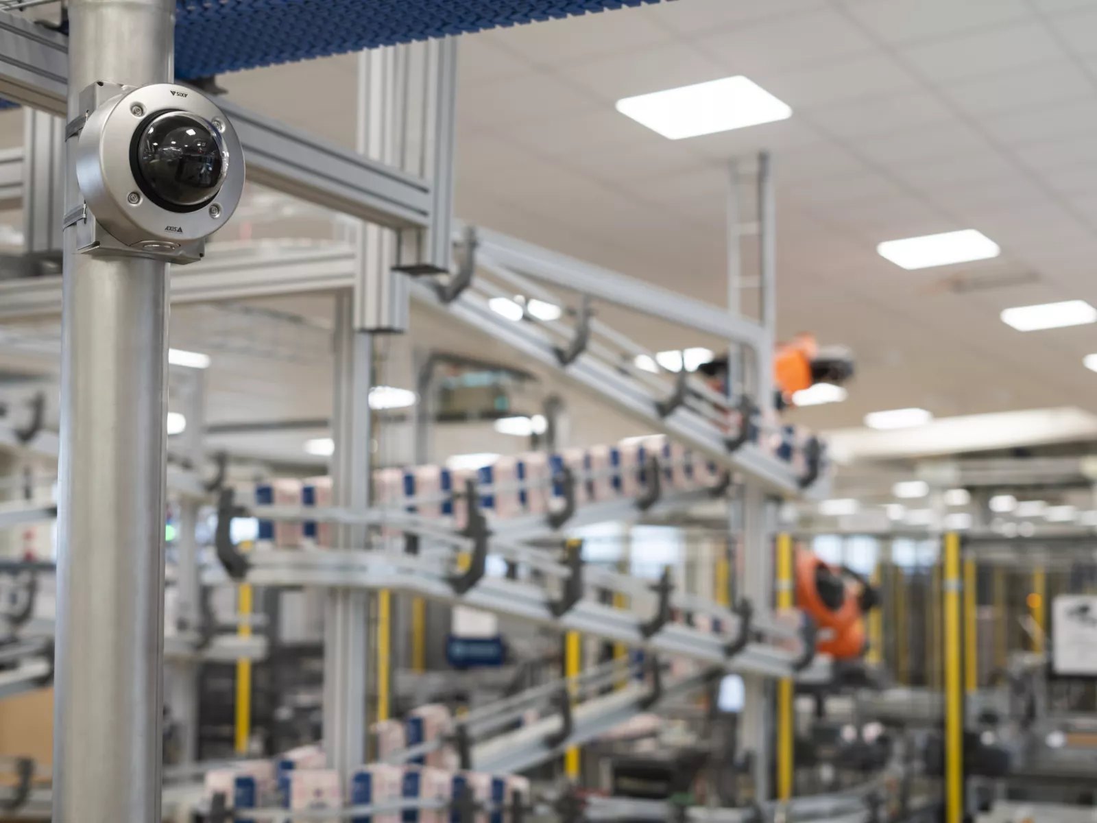 Dome camera on a stainless post watching a packaging line